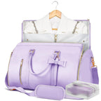 A lavender purple travel duffel bag set with gold zippers, shown with a matching garment bag containing a white shirt and a small zippered pouch on a white background.